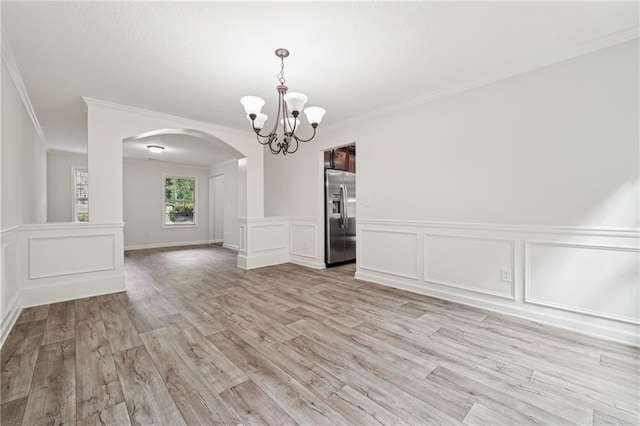 56 Sugar Leaf Ln, Jefferson, GA 30549 - unfurnished dining area with arched walkways, crown molding, a chandelier, light wood-style flooring, and wainscoting