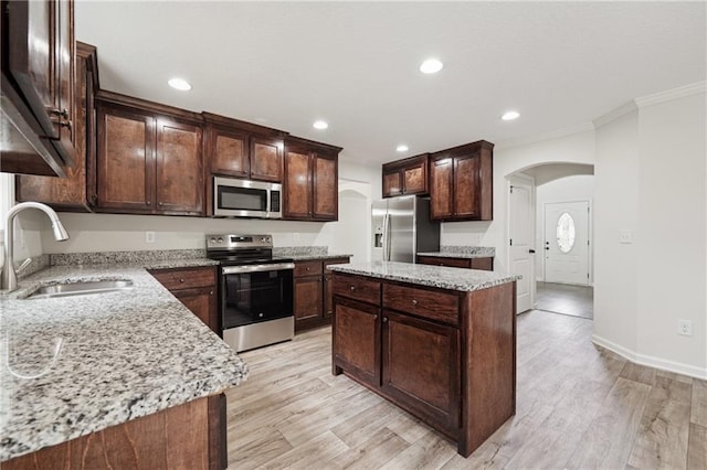 56 Sugar Leaf Ln, Jefferson, GA 30549 - kitchen featuring stainless steel appliances, arched walkways, crown molding, a kitchen island, and light stone countertops