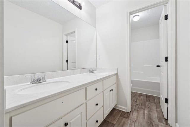 56 Sugar Leaf Ln, Jefferson, GA 30549 - bathroom with double vanity, wood finished floors, and a textured ceiling