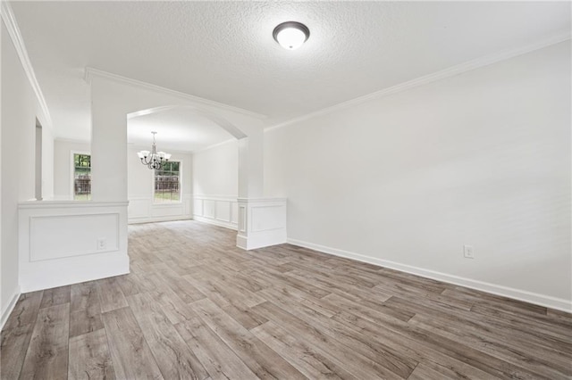56 Sugar Leaf Ln, Jefferson, GA 30549 - spare room featuring a chandelier, crown molding, arched walkways, wood finished floors, and a textured ceiling