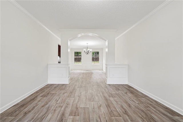 56 Sugar Leaf Ln, Jefferson, GA 30549 - empty room with a chandelier, arched walkways, wood finished floors, ornamental molding, and a textured ceiling