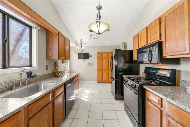 kitchen featuring light tile patterned floors, hanging light fixtures, a textured ceiling, black appliances, and a sink