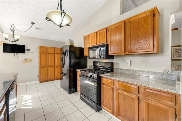 kitchen featuring brown cabinets, lofted ceiling, a textured ceiling, light stone countertops, and black appliances