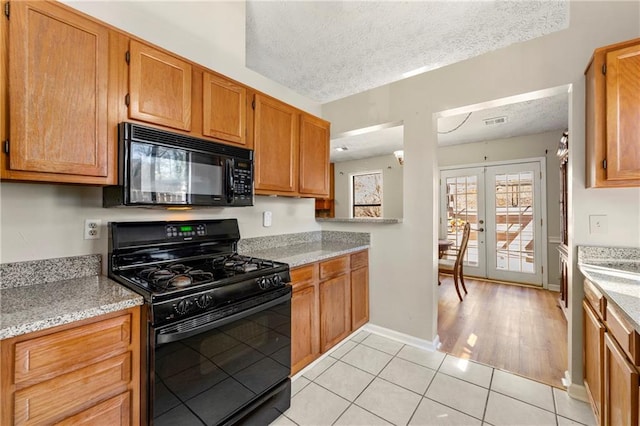 kitchen featuring french doors, light tile patterned floors, visible vents, a textured ceiling, and black appliances