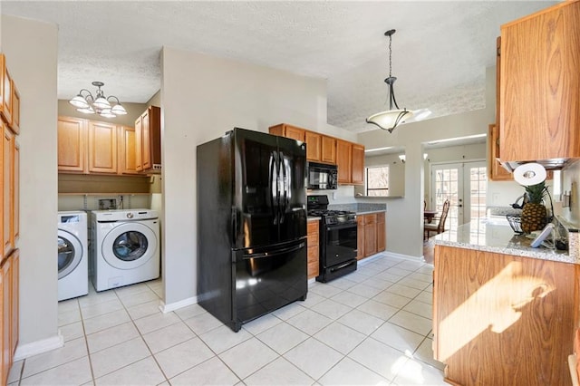 kitchen with washing machine and clothes dryer, a textured ceiling, french doors, black appliances, and light tile patterned flooring