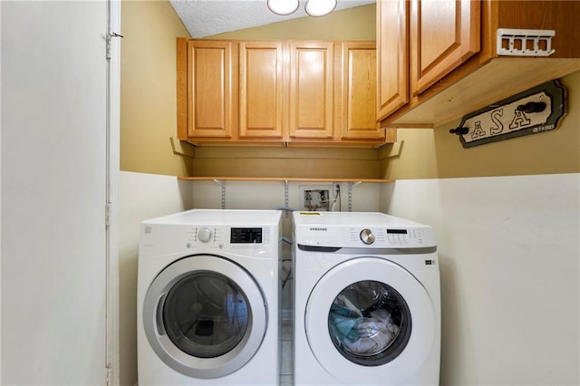 washroom featuring washing machine and dryer and cabinet space