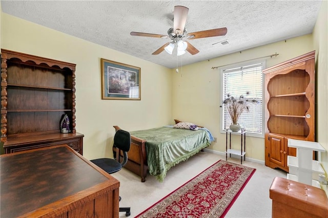 bedroom with a textured ceiling, ceiling fan, visible vents, baseboards, and carpet