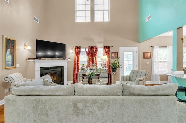 living room featuring wood-type flooring and a towering ceiling