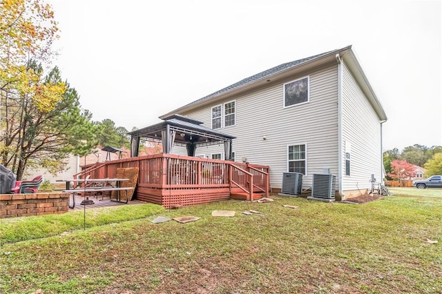 rear view of property with a gazebo, a yard, central air condition unit, and a wooden deck