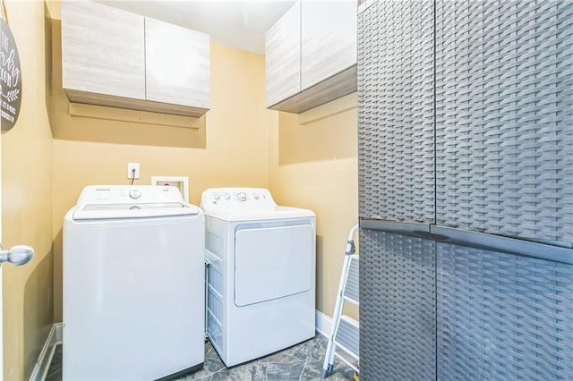 laundry room featuring washing machine and dryer and cabinets