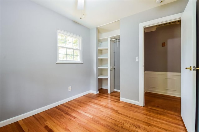 unfurnished bedroom with light wood-type flooring, a closet, and baseboards
