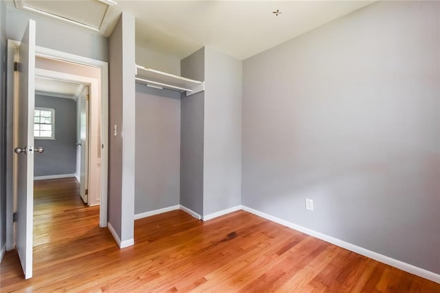 unfurnished bedroom featuring baseboards, a closet, and light wood-style flooring