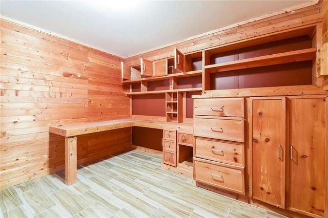 unfurnished office featuring built in desk and wood walls