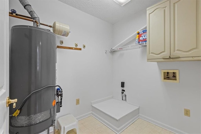 washroom with water heater, washer hookup, cabinet space, light flooring, and a textured ceiling