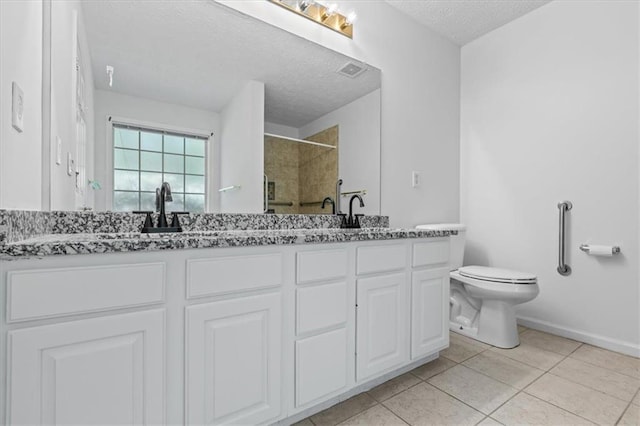 full bathroom with a shower stall, a textured ceiling, toilet, double vanity, and tile patterned flooring