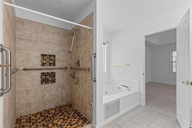 bathroom with tile patterned floors, a textured ceiling, a shower stall, and a bath