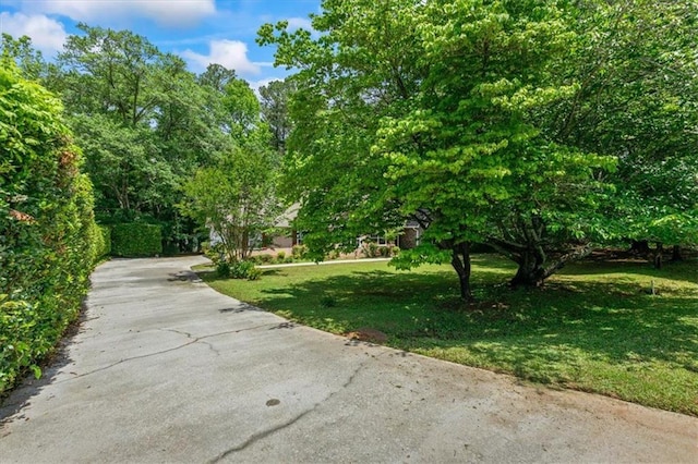 view of home's community featuring a yard and asphalt driveway