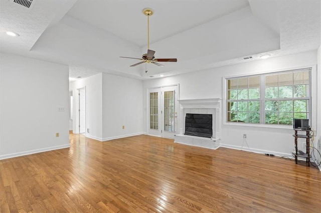 unfurnished living room featuring ceiling fan, wood finished floors, a fireplace, baseboards, and recessed lighting