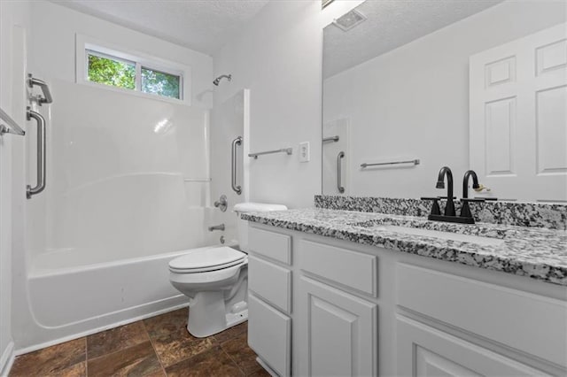 bathroom featuring a textured ceiling, toilet, vanity, and bathtub / shower combination