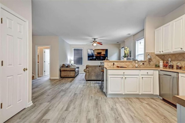 kitchen with decorative backsplash, stainless steel dishwasher, ceiling fan, light hardwood / wood-style flooring, and white cabinets