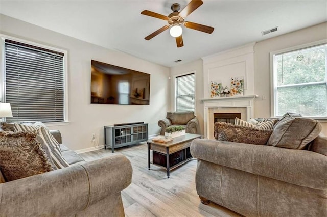 living room with ceiling fan and light hardwood / wood-style flooring