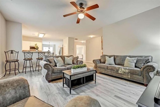 living room with ceiling fan and light hardwood / wood-style floors