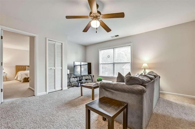 carpeted living room with ceiling fan