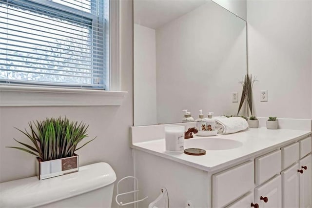 bathroom featuring a wealth of natural light, vanity, and toilet