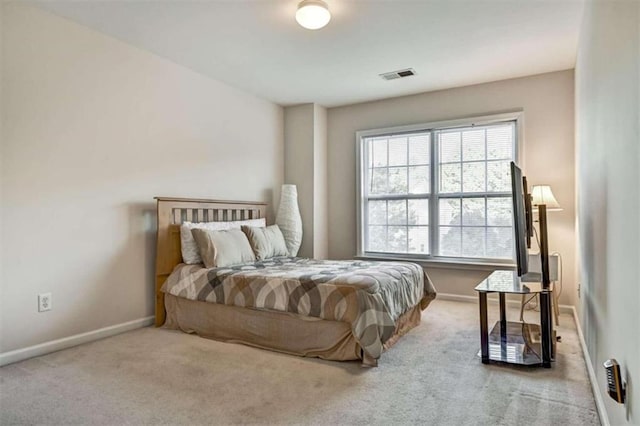 bedroom with light colored carpet and multiple windows