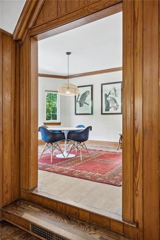 dining space featuring ornamental molding and hardwood / wood-style flooring