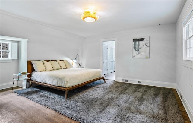 bedroom with ensuite bathroom and wood-type flooring