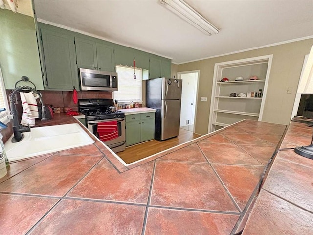 1146 Nelson St, Jackson, GA 30233 - kitchen featuring appliances with stainless steel finishes, green cabinetry, built in shelves, ornamental molding, and tile countertops