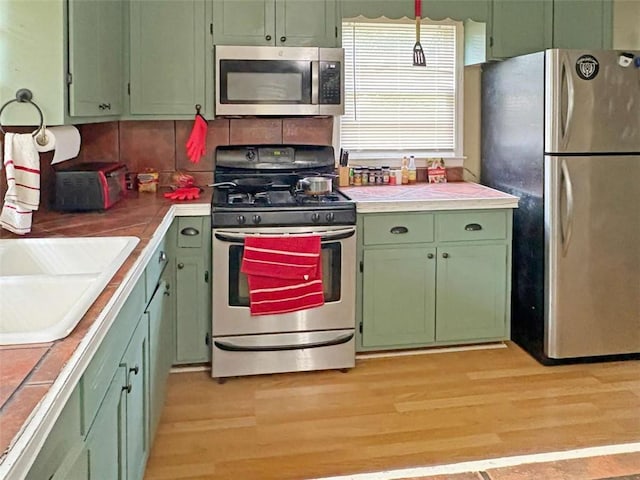 1146 Nelson St, Jackson, GA 30233 - kitchen with stainless steel appliances, green cabinetry, and light wood finished floors