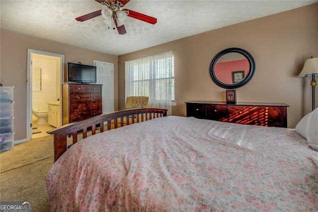 bedroom featuring ceiling fan, carpet floors, connected bathroom, and a textured ceiling