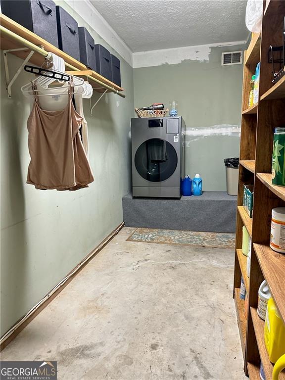 laundry room featuring washer / clothes dryer and a textured ceiling