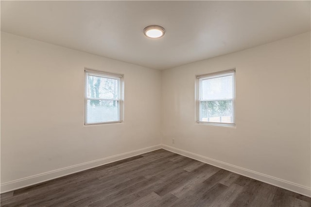 unfurnished room featuring plenty of natural light and dark hardwood / wood-style floors