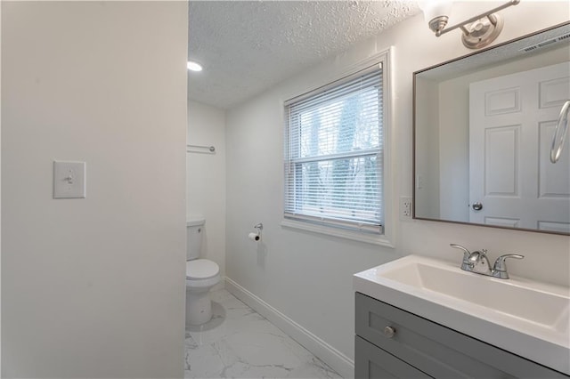 bathroom featuring vanity, toilet, and a textured ceiling