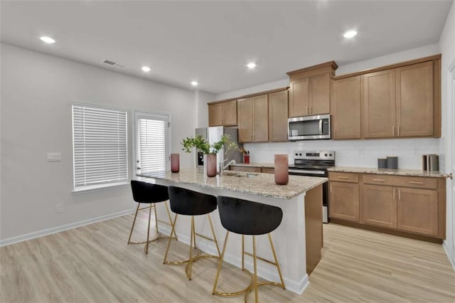 2766 Aralynn Way, College Park, GA 30337 - kitchen featuring stainless steel appliances, a kitchen breakfast bar, light wood-style floors, a kitchen island with sink, and recessed lighting