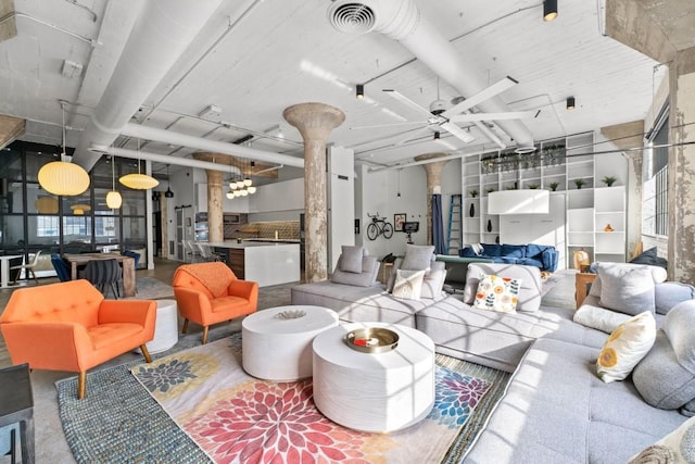 living room featuring visible vents, concrete floors, and decorative columns