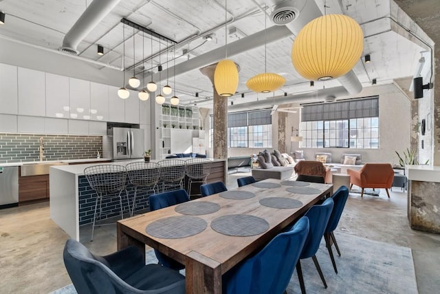 dining room with a wealth of natural light, visible vents, and concrete floors