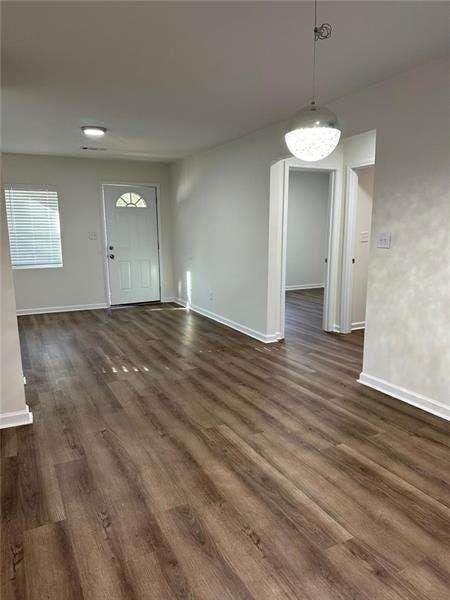 interior space featuring dark wood-style flooring and baseboards