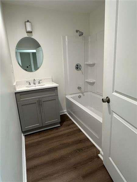 full bathroom featuring wood finished floors, shower / bathing tub combination, and vanity
