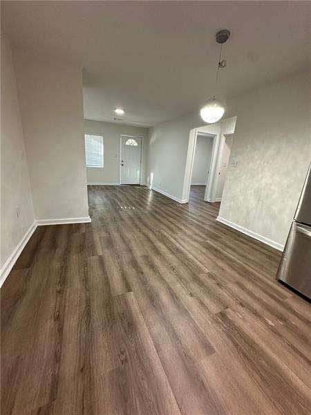 unfurnished dining area with baseboards and wood finished floors