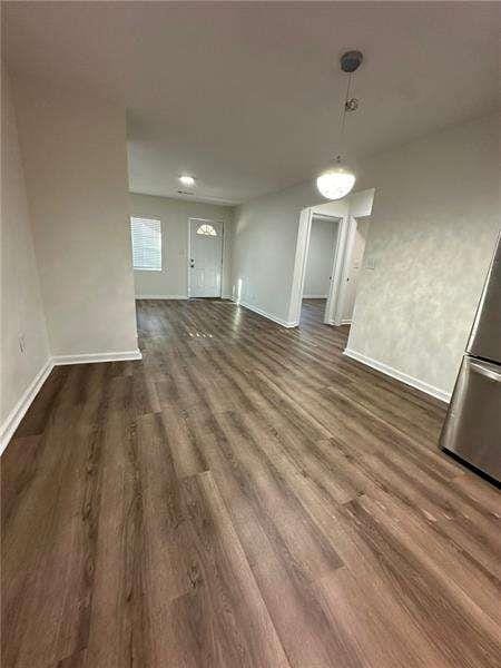 unfurnished dining area with baseboards and wood finished floors