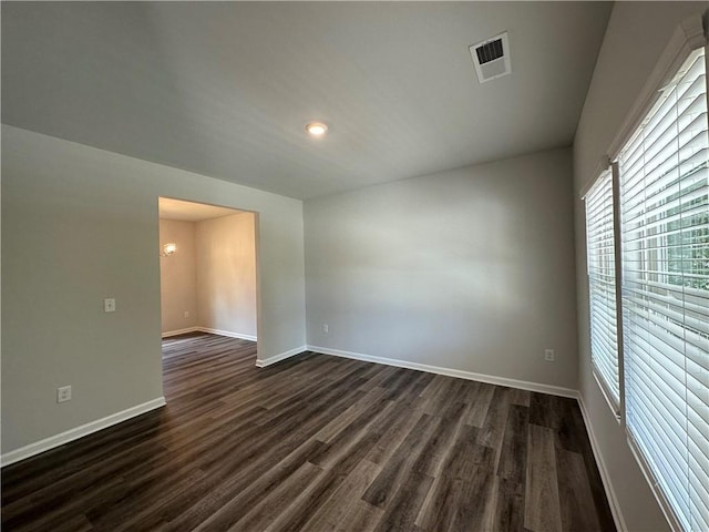 unfurnished room featuring dark wood-type flooring and a chandelier