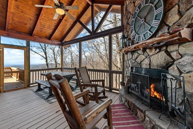 wooden terrace featuring outdoor dining space and a fireplace