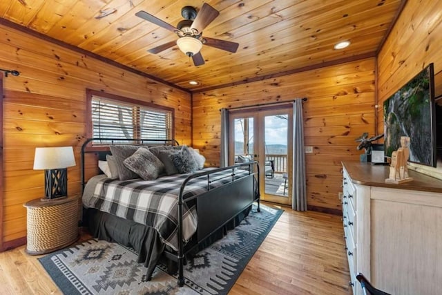 bedroom featuring light wood-style flooring, multiple windows, and access to outside