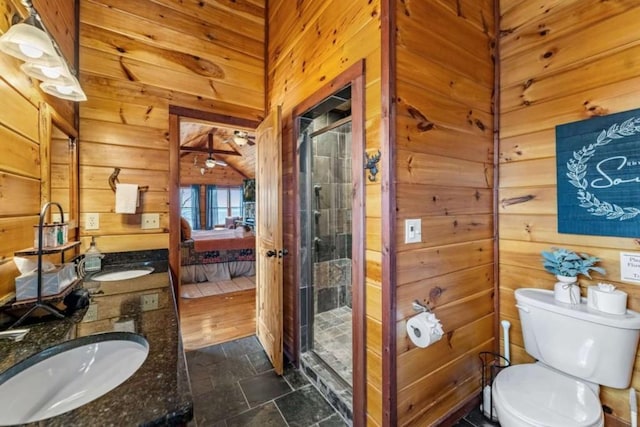 full bath with a sink, connected bathroom, a stall shower, and wood walls