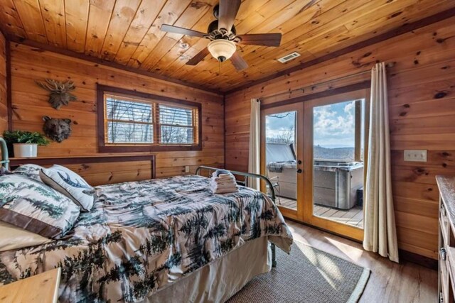 bedroom featuring wood walls, french doors, wooden ceiling, wood finished floors, and access to outside