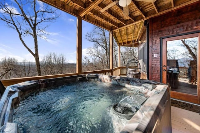 wooden deck with a grill, a ceiling fan, and a hot tub